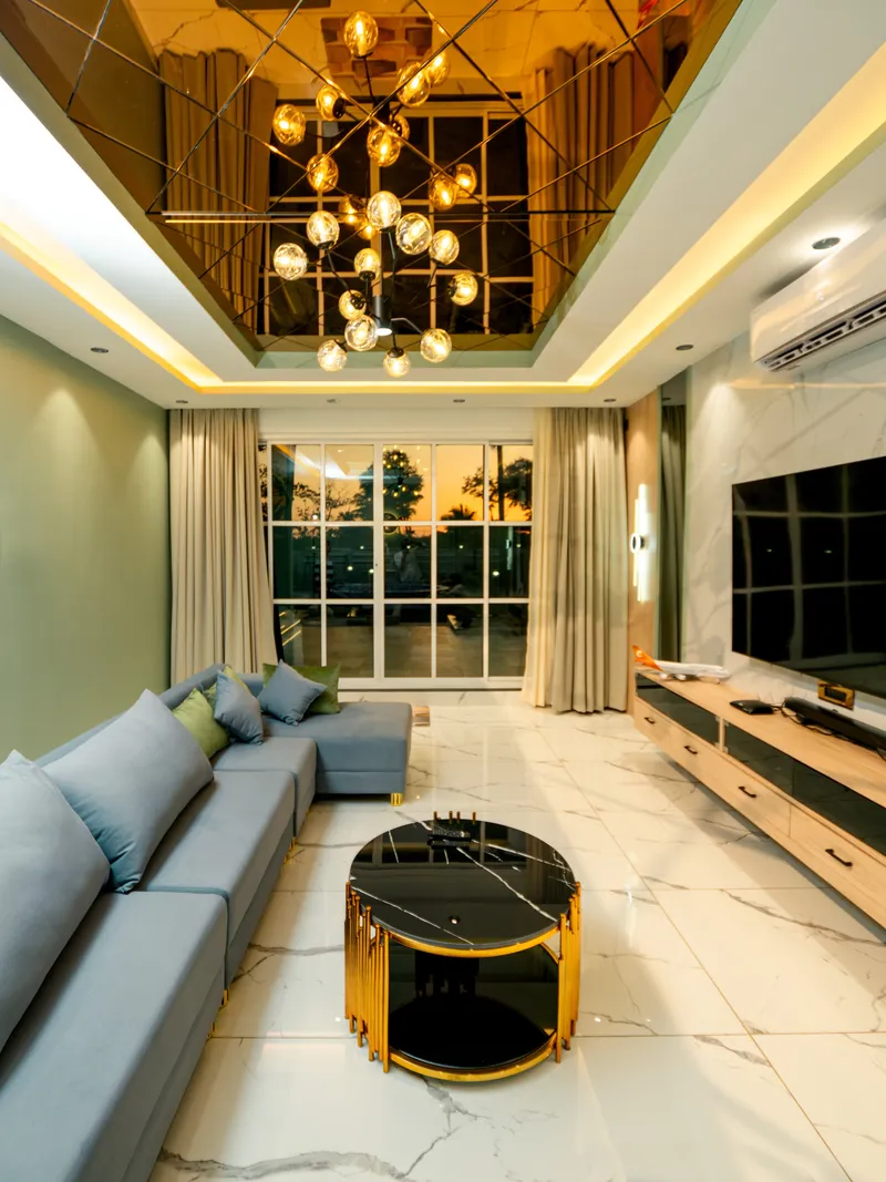 Luxury living room with mirrored ceiling and elegant furniture with gold accents in villa at Nanu Beach retreat