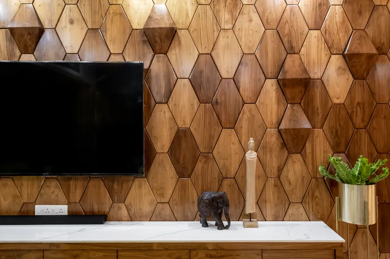 The exquisite wooden backdrop elegantly frames the wall mounted TV unit imparting a timeless elegance and redefined warmth to the space