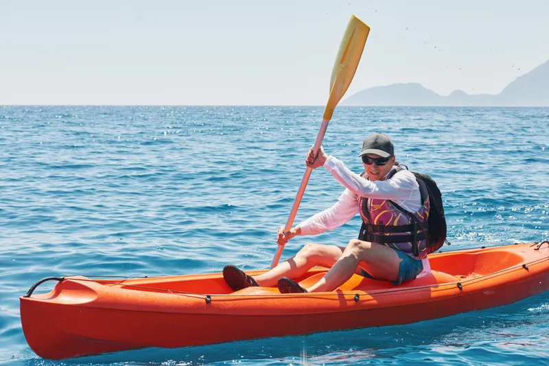 boat kayaking near cliffs sunny day travel sports concept lifestyle
