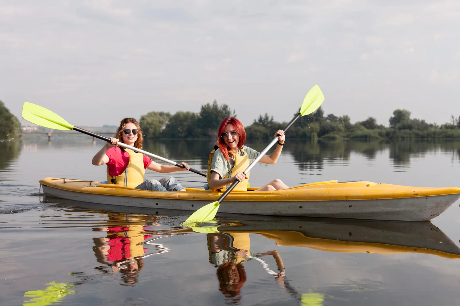 girls rowing kayak lake scaled