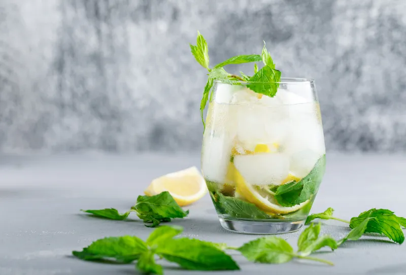 icy detox water with lemon mint glass grey grunge surface