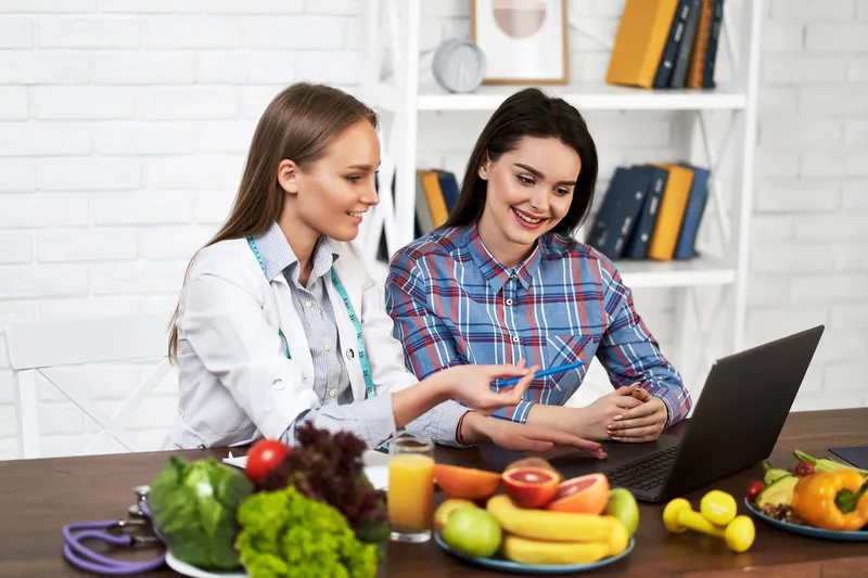 smiling nutritionist advises young patient woman proper nutrition dieting