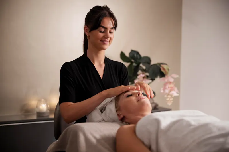 young woman massaging her client s face