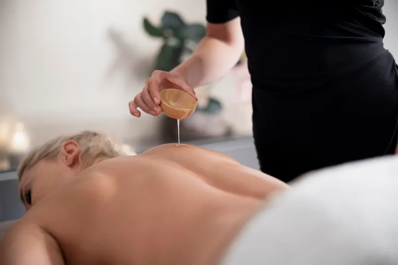 young woman using massage oil her client